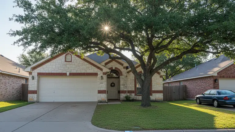 Closed white garage door on a limestone and brick Round Rock home under a live oak on a quiet morning